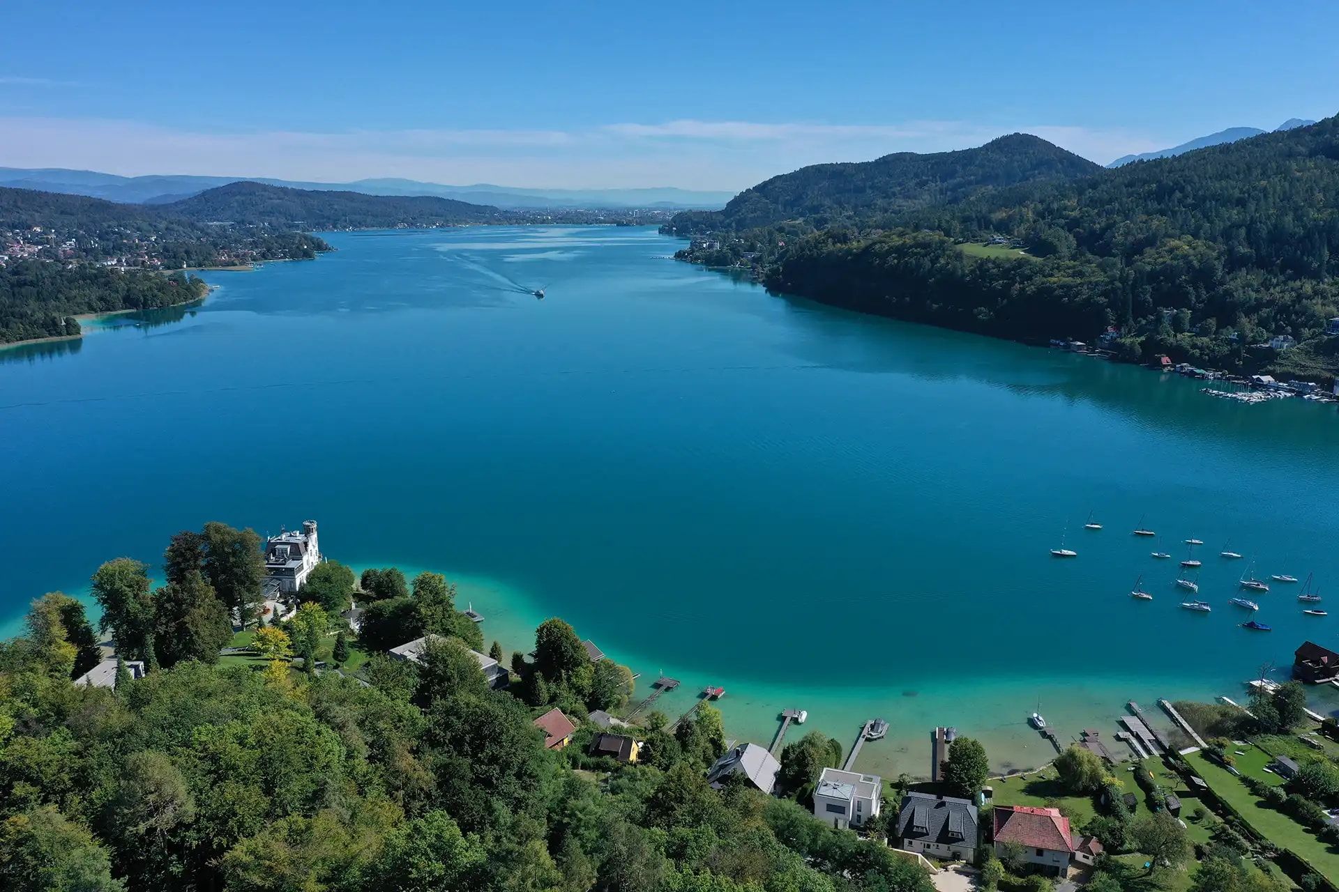 Türkiser See mit Halbinsel und Bergen aus der Luft